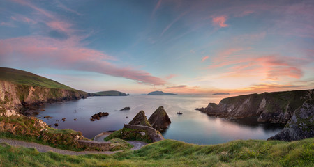 Irish landscape with rocks and steep road to quay where a little ferry departs to Blasket Island,...