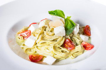Pasta spaghetti with tomatoes, mozzarella and Pesto sauce