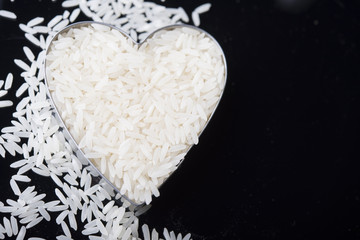 Rice in heart bowl on white rice background