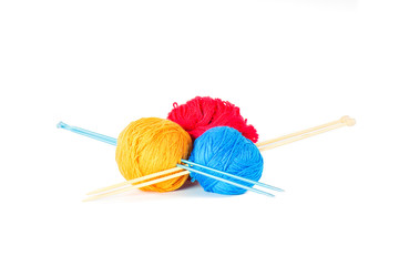 Three wool balls skewered by knitting needles.