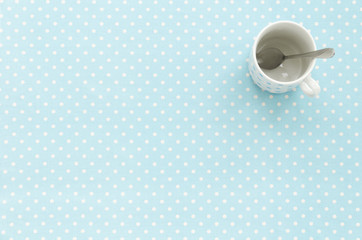 Empty cup with teaspoon. Polka dot background