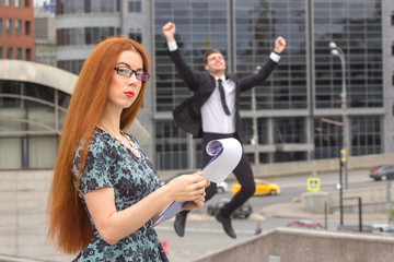 Red-haired businesswoman and businessman on background
