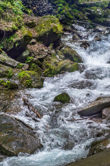 Fototapeta premium Mountain seething сreek. Flow of water in rocky terrain