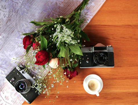 vintage camera near a bouquet of flowers and candles