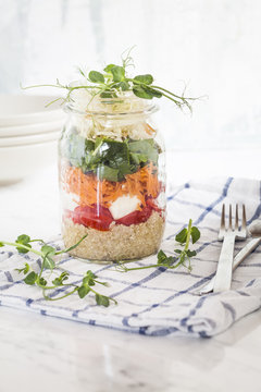 Rainbow salad in a jar, quinoa, tomatoes, mozzarella, spinach, pea sprouts