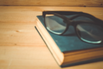 Old books and glasses on a wooden table with filter effect retro