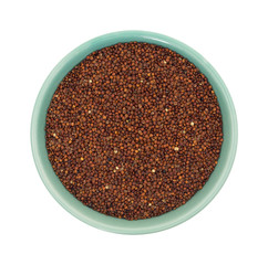 Red quinoa in a small bowl isolated on a white background top view