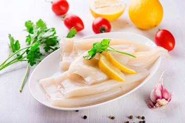 Raw squid and ingredients on the white plate