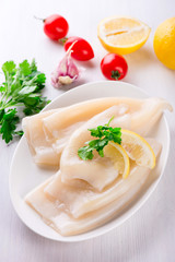 Raw squid and ingredients on the white plate
