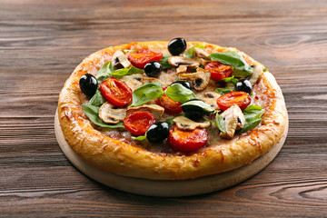 Delicious tasty pizza with ingredients on wooden table