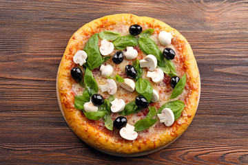 Delicious tasty pizza with ingredients on wooden table