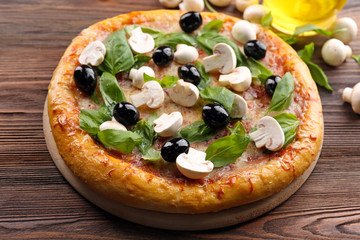 Delicious tasty pizza with ingredients on wooden table