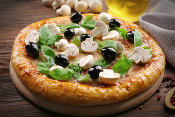 Delicious tasty pizza with ingredients on wooden table