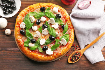 Delicious tasty pizza with ingredients on wooden table