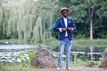 Stylish smiled african american man at blue jacket, sunglasses a