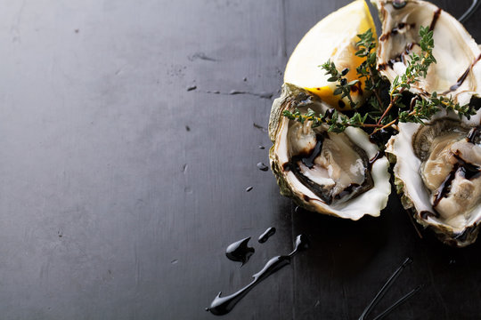 Fresh Oysters in shell with sauce and lemon