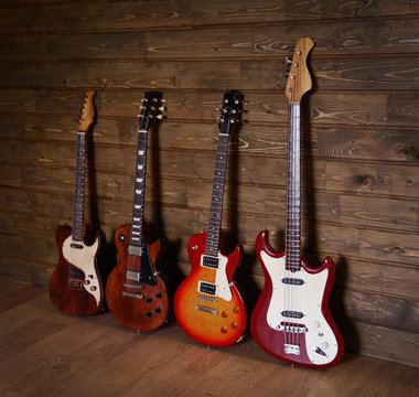 Four electric guitars on wooden background