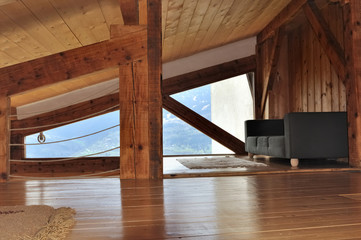 intérieur bois d'un chalet sous pente de toit avec canapé 