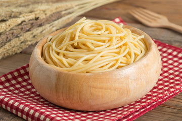 Boiled spaghetti in wood bowl.