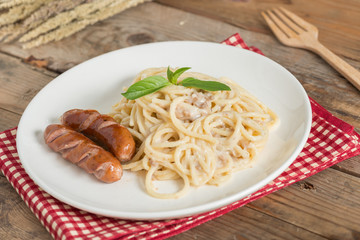 Spaghetti cream sauce chopped mushroom with sausage.