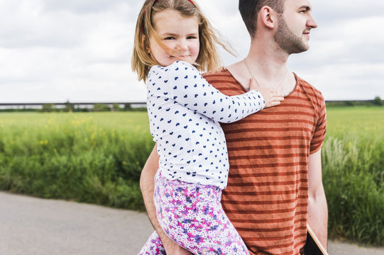 Father holding daughter outdoors