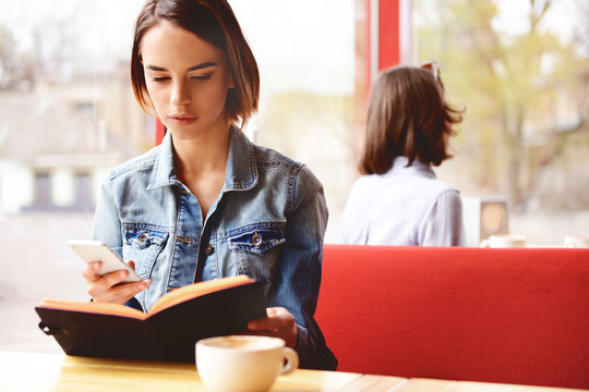 Young woman with book sitting in cafe