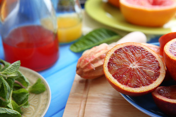 Juicing delicious citruses on blue wooden table