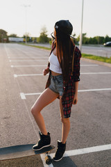 Hipster girl with skateboard. Lifestyle outdoor portrait