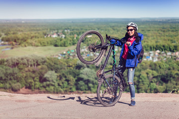 Naklejka premium happy young women traveler on bicycle with arms and legs raised expressing freedom and enthusiasm