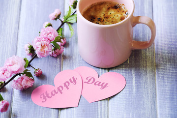 Cup of fresh coffee and cards on wooden background