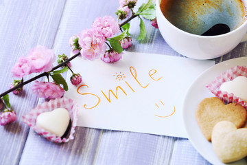 Cup of fresh coffee and note on wooden background