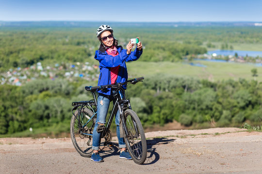 Beautiful woman cyclist take a self portrait with smart phone