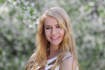 Fototapeta premium Young beautiful woman on blooming tree background