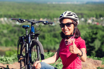 Fototapeta na wymiar Cyclist Woman Showing Thumb Up gesture, Outdoor