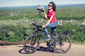 Fototapeta na wymiar Bike helmet - woman putting biking helmet on during bicycle ride.