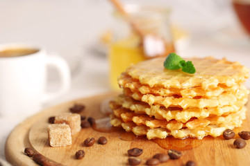 Tasty waffles with honey and mint on cutting board