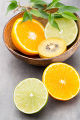 Fototapeta na wymiar Mixed citrus fruit lemons, orange, kiwi, limes on a gray backgro