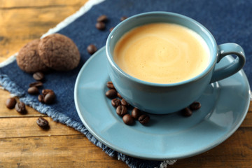 Cup of coffee with cookies on wooden table