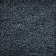 Dark grey / black slate stone background or texture.