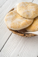 Pita, napkin, basket on wooden boards