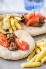 Pita gyros, fried potatoes, tomato, meat on parchment