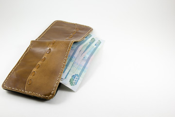 Bank notes sticking out of a purse on a white background