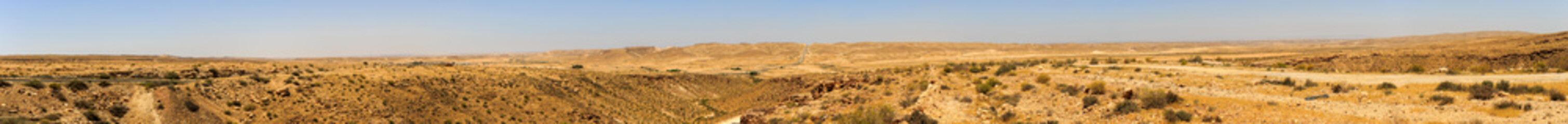 Wide panorama of mountains in Negev desert with road