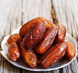 Dates fruit on wooden background, selective focus