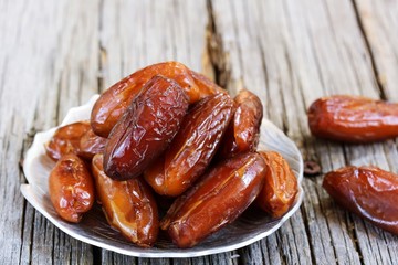 Dates fruit on wooden background, selective focus