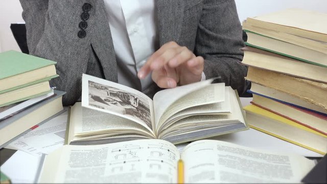 close up video of reading student, surrounded by books. 4k people stock footage clip at white background. 

