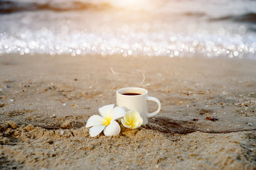 Coffee on the beach and frangipani flower.