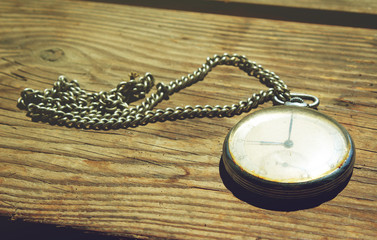 Old pocket watch on a wooden background