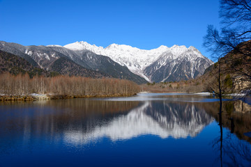 Fototapeta na wymiar Lake Taisho and Hotaka mountains in winter in Kamikochi, Nagano, Japan