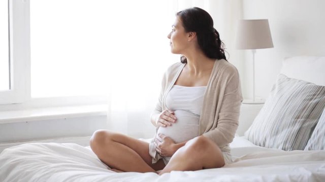 happy pregnant woman touching her tummy at home 11